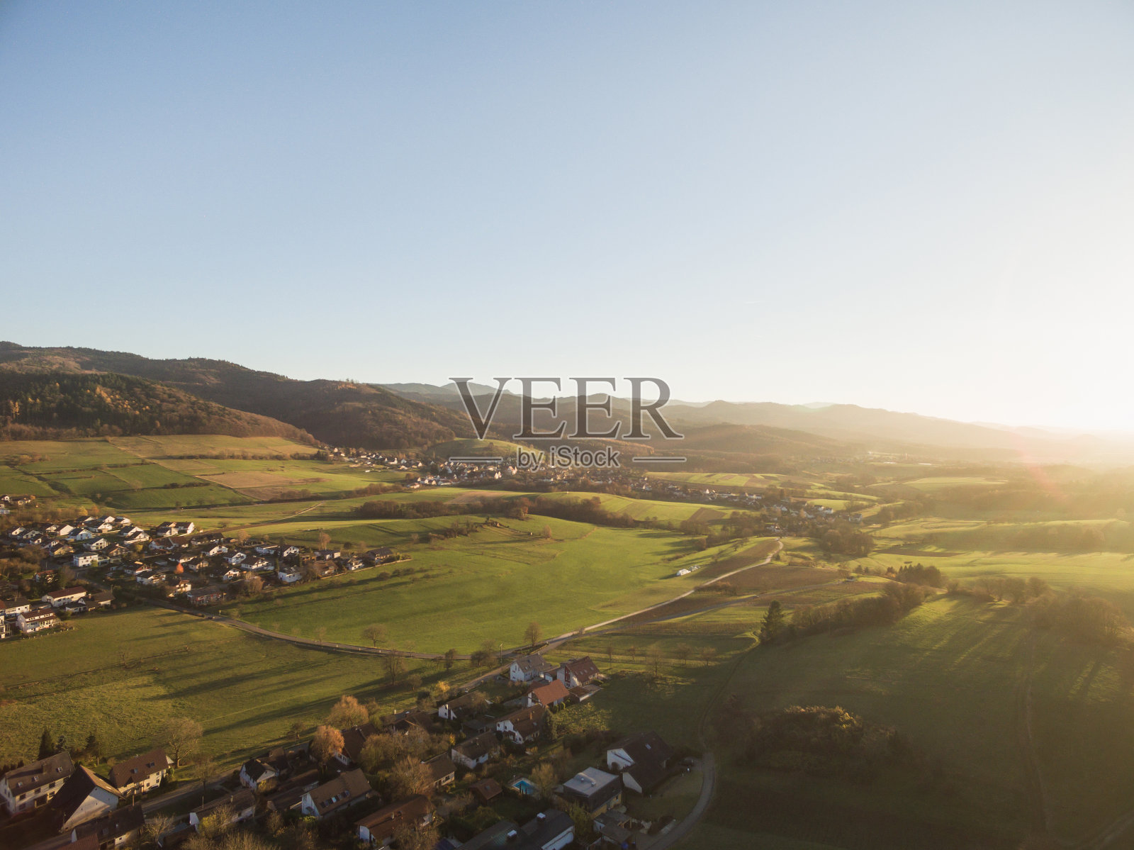 鸟瞰图的屋顶，房子和美丽的绿色山丘与树木在阳光下，德国照片摄影图片