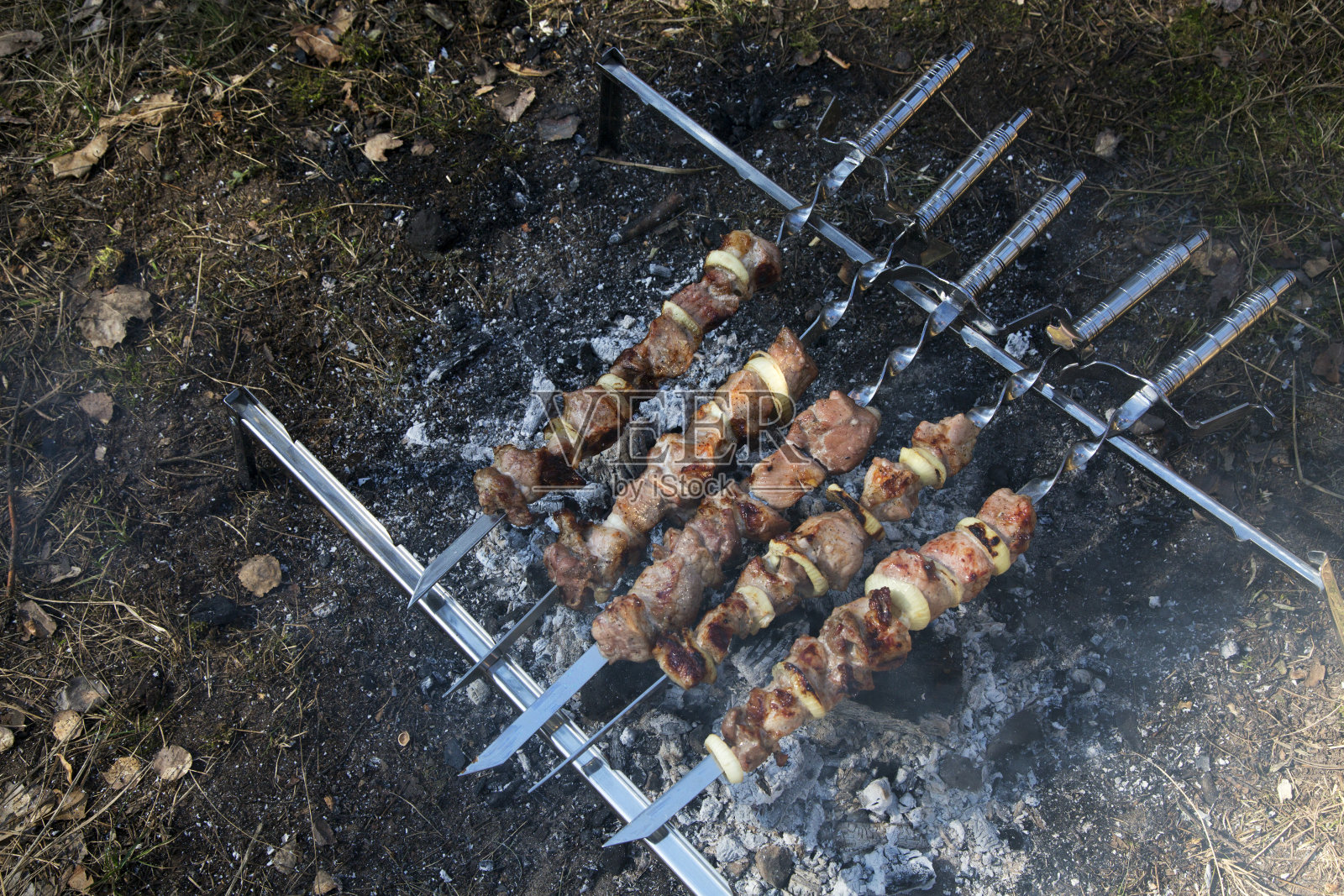 多汁和美味的猪肉串串在露天烧烤。户外烧烤派对的概念。初春的一天。肉的背景。前视图。照片摄影图片