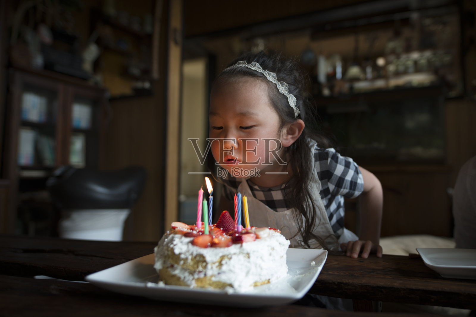 小女孩吹灭生日蛋糕蜡烛照片摄影图片