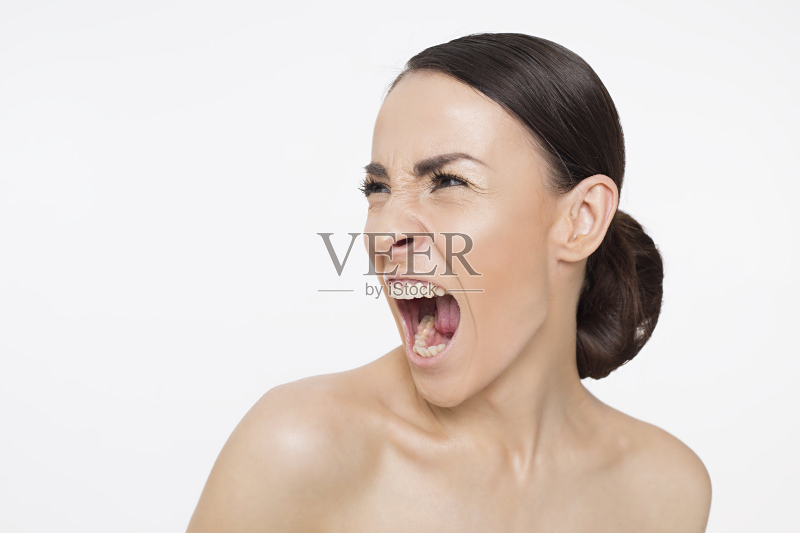 一个年轻女人的肖像，愤怒地向旁边尖叫。照片摄影图片