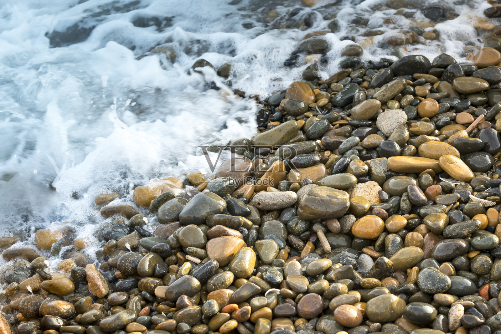 温暖的夏日，沙滩上的鹅卵石，照片摄影图片