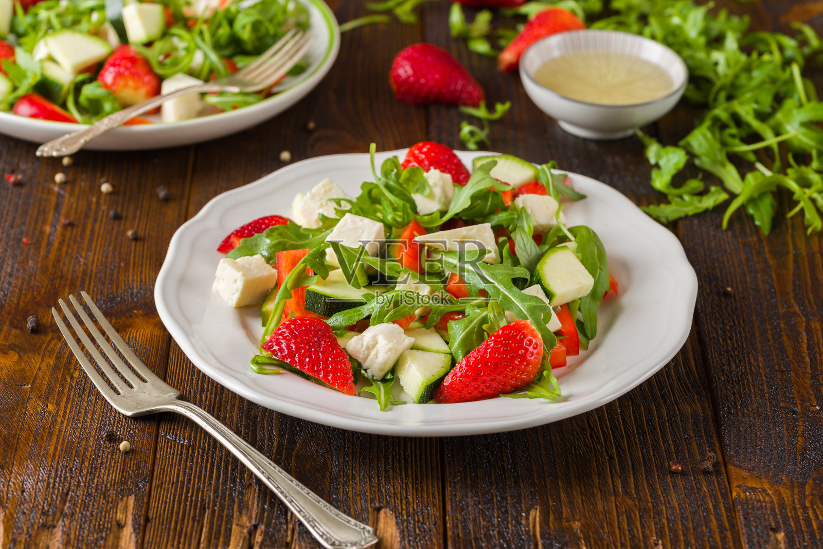 新鲜蔬菜草莓沙拉，白色盘子，自然质朴的书桌。照片摄影图片