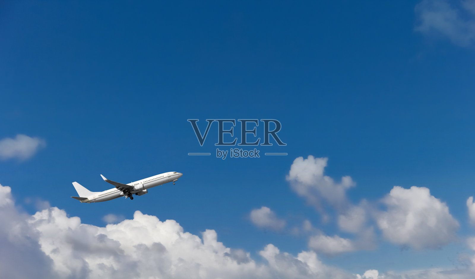 一架客机在蓝天白云的背景下降落在机场。照片摄影图片