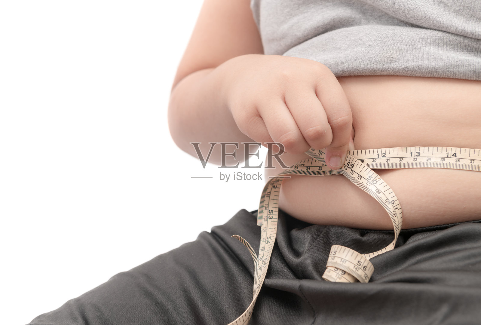 胖小孩用卷尺测量身体脂肪照片摄影图片