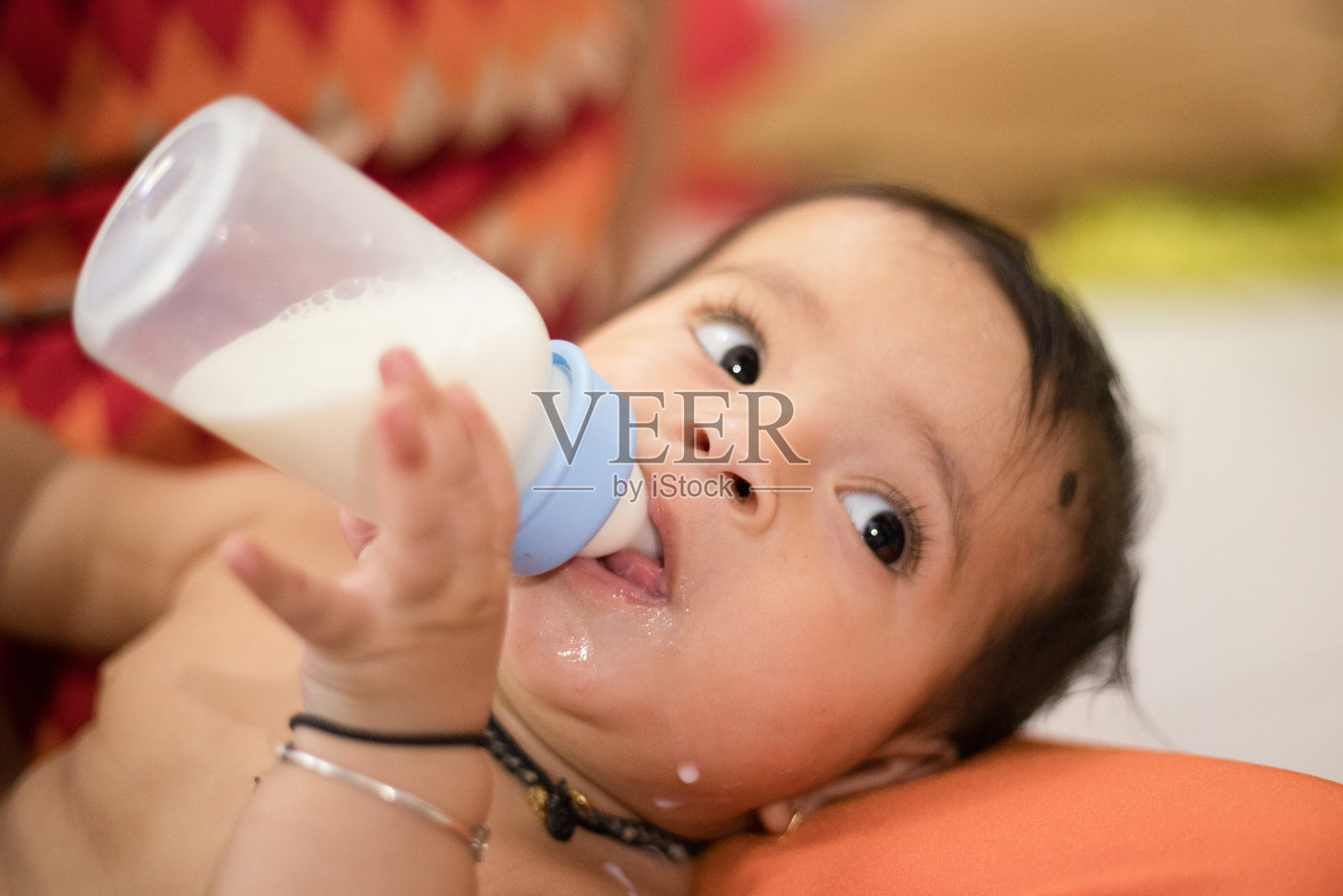 女婴在喝奶瓶里的牛奶照片摄影图片