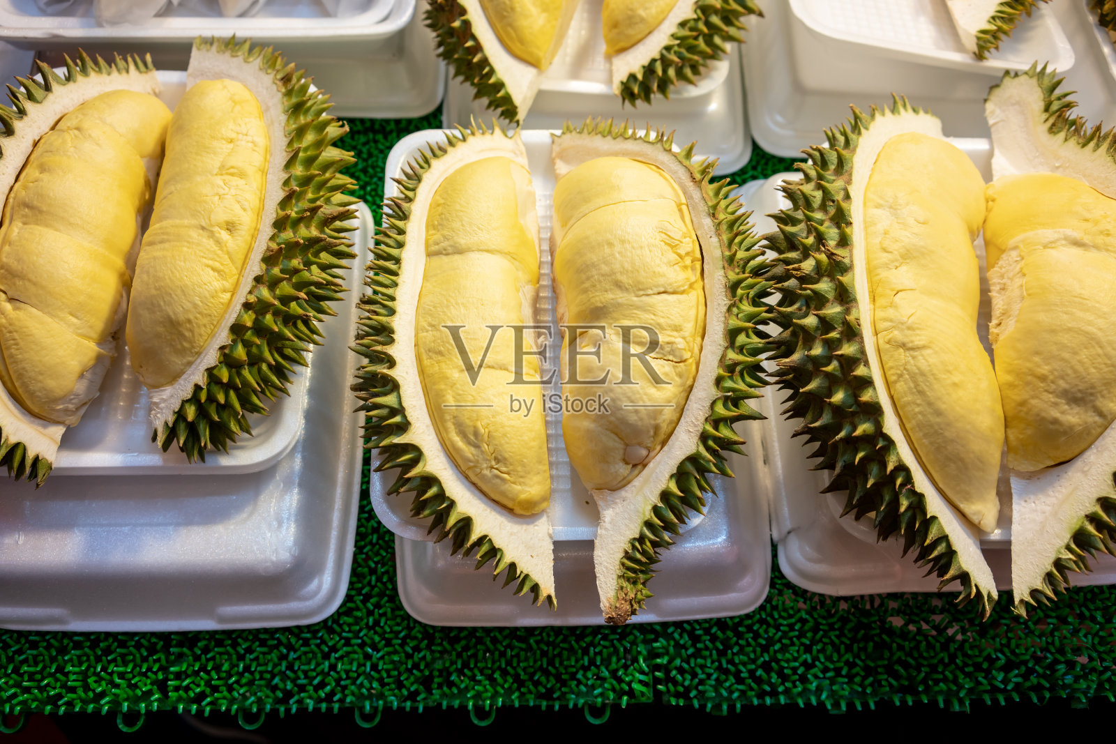 白色泡沫盘子里的榴莲正在出售。黄色新鲜durain是泰国的水果之王。照片摄影图片