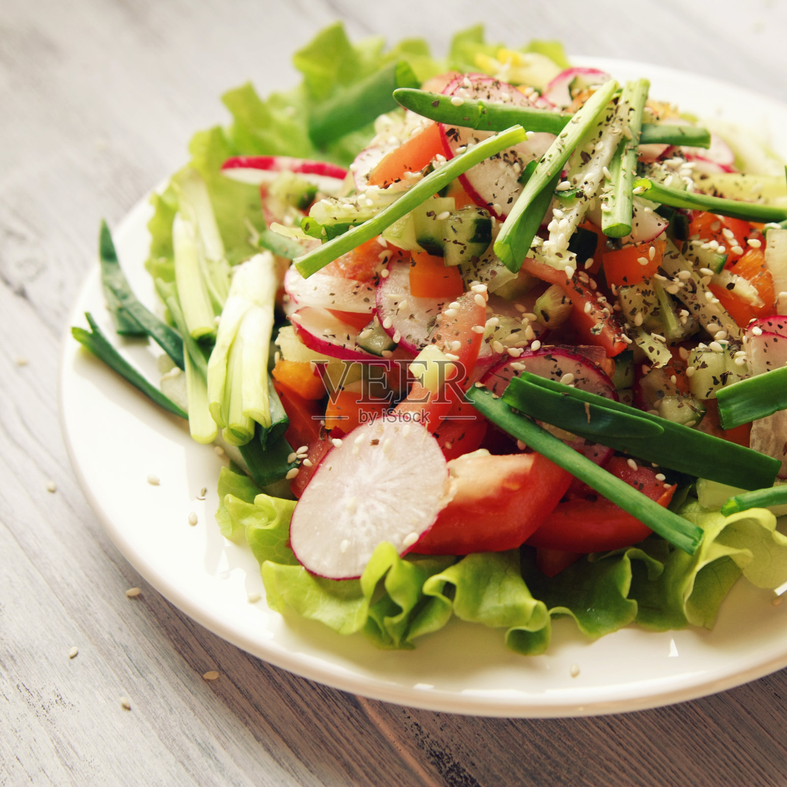 春季蔬菜沙拉放在白色的盘子里。素食主义者。照片摄影图片