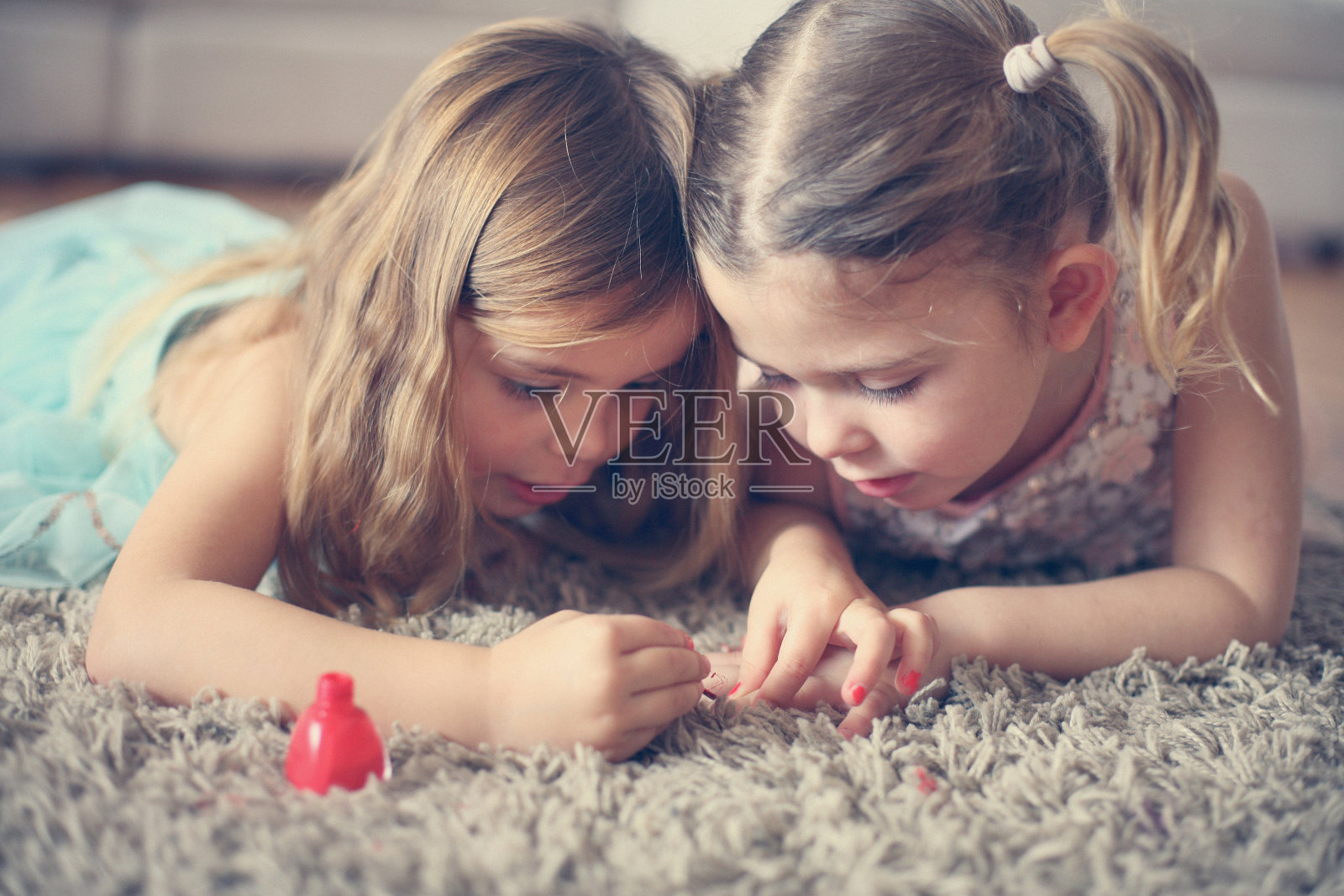 近距离拍摄两个小女孩在做指甲。照片摄影图片