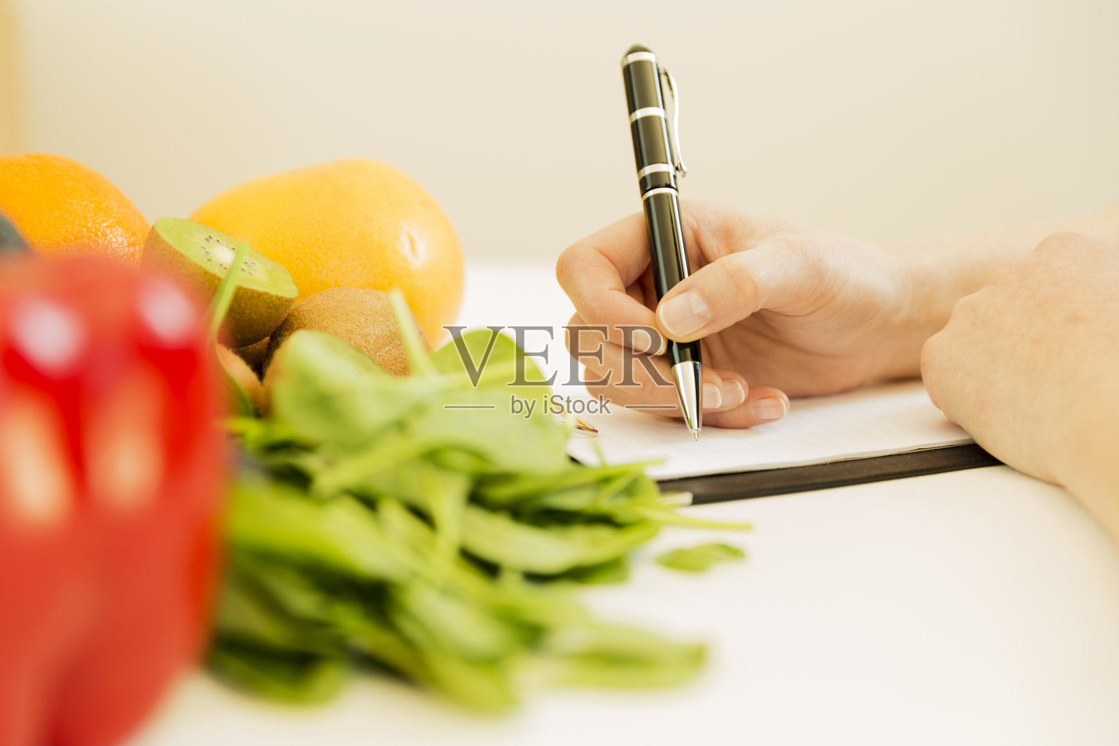 营养学家在桌子上写满了水果和蔬菜的饮食计划照片摄影图片
