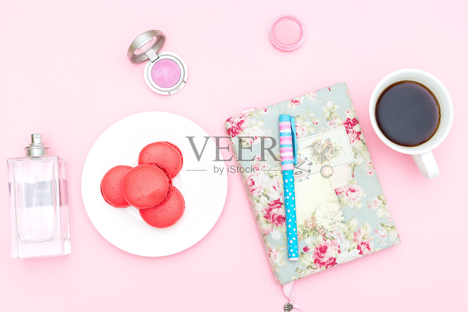 粉色背景上的女性办公桌和配饰。休息时间照片摄影图片