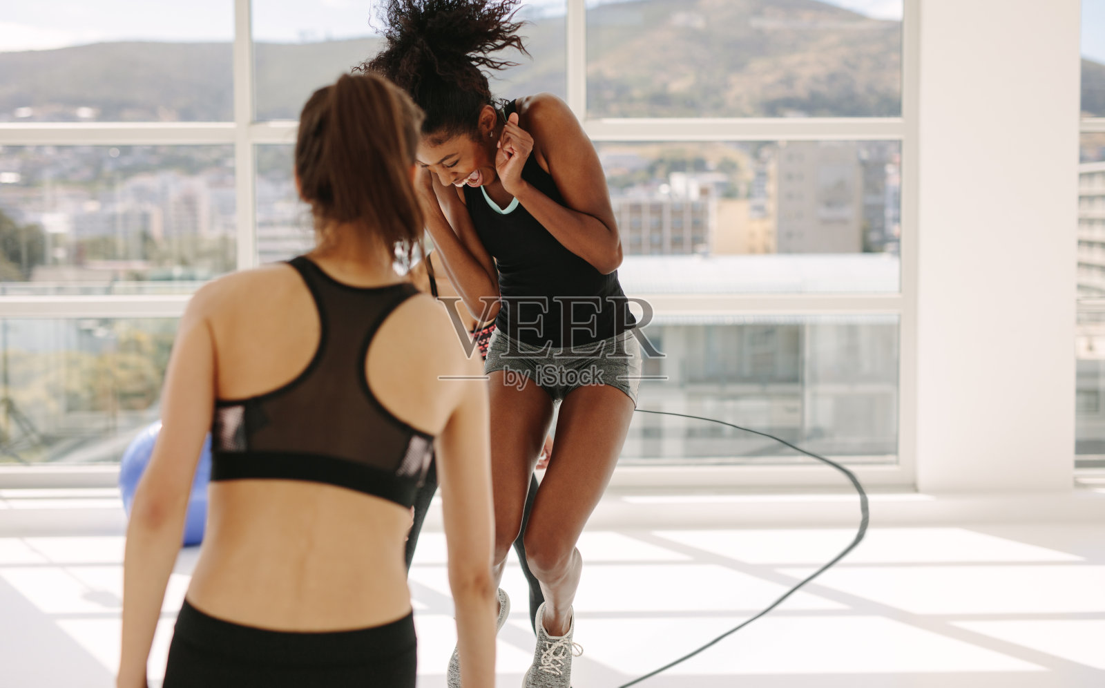 在健身房锻炼期间玩得开心的女人照片摄影图片