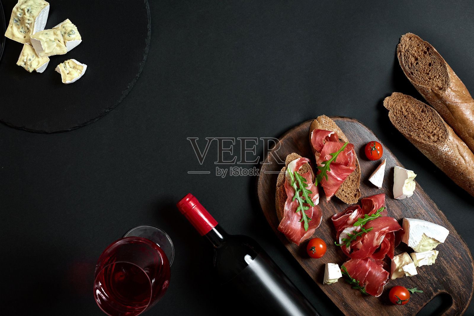 酒瓶与奶酪和传统的香肠在木板上的黑色背景与复制空间照片摄影图片