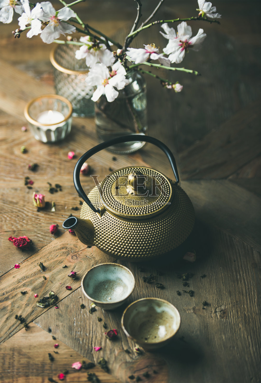 金铁茶壶，茶杯，干玫瑰，蜡烛和杏花照片摄影图片