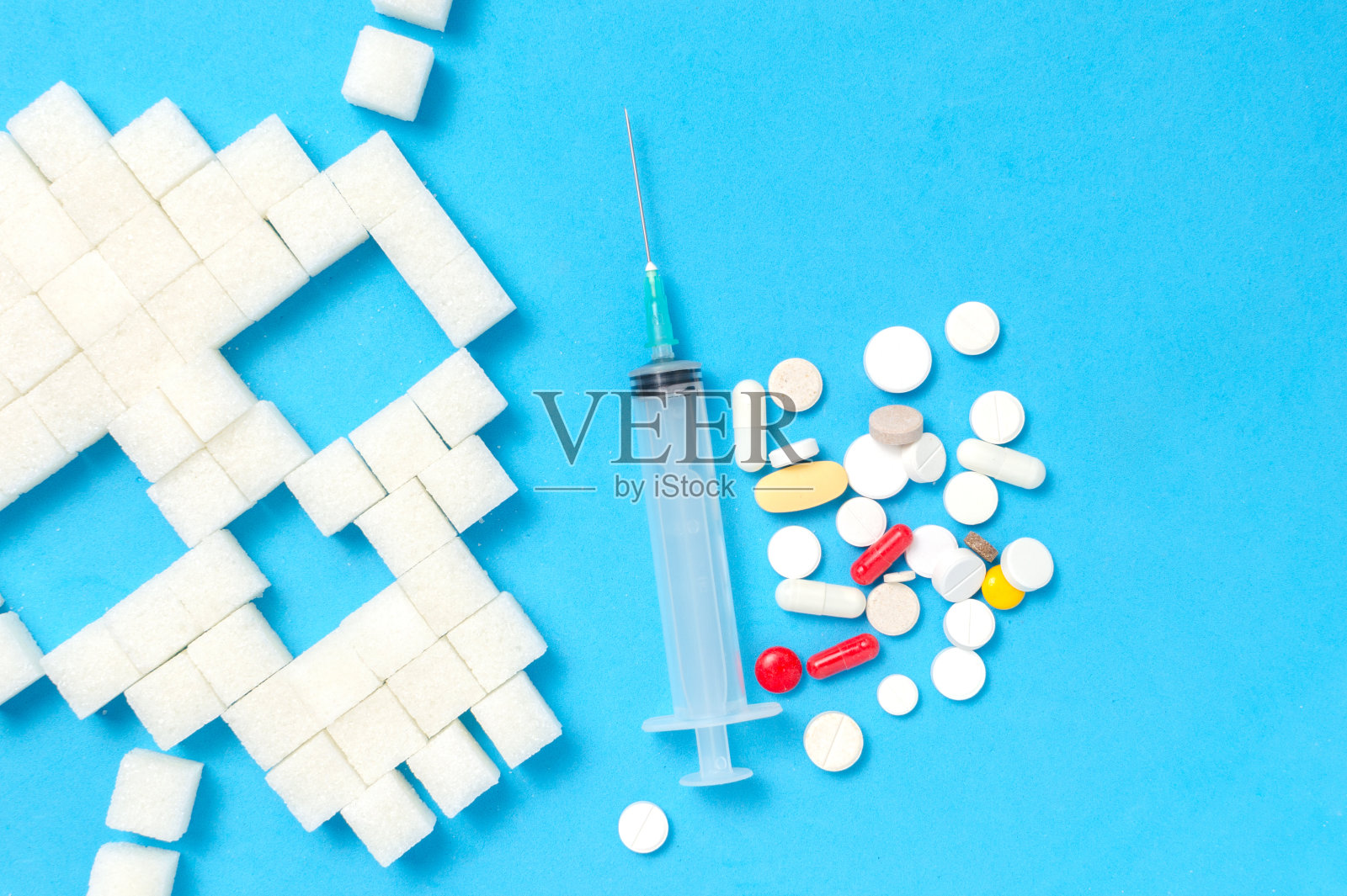 糖以头骨，注射器，药片和药丸的形式在蓝色的背景。照片摄影图片