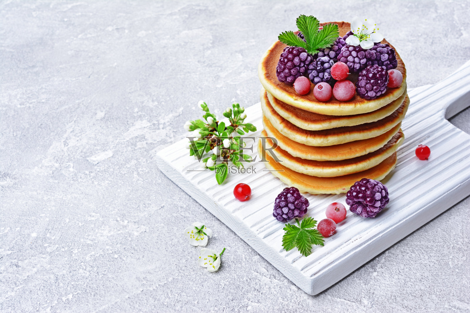 自制煎饼配上冰冻的蔓越莓、黑莓和春花照片摄影图片