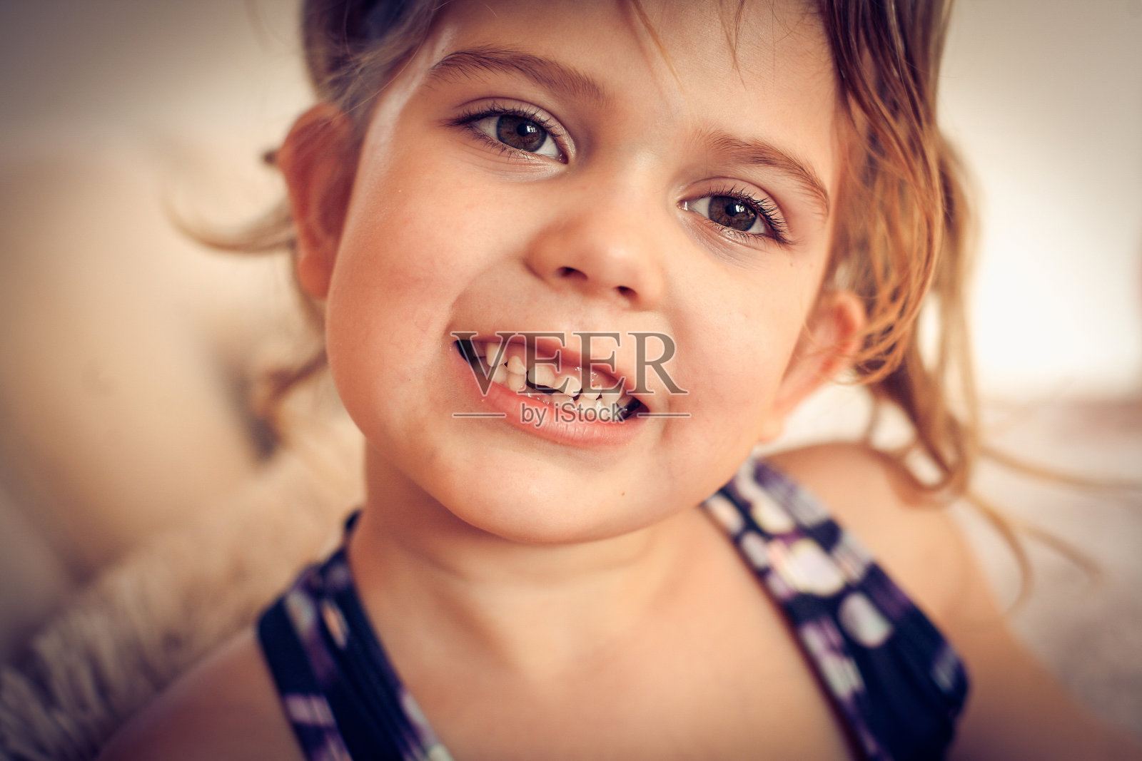 小女孩露出缺牙。照片摄影图片