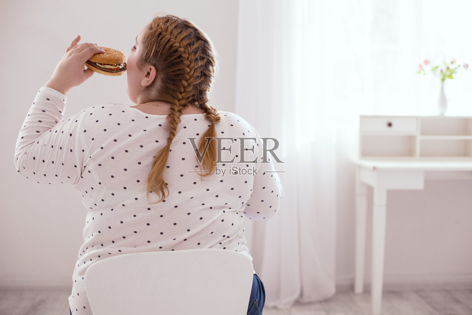 吃垃圾食品的胖乎乎的年轻女人照片摄影图片