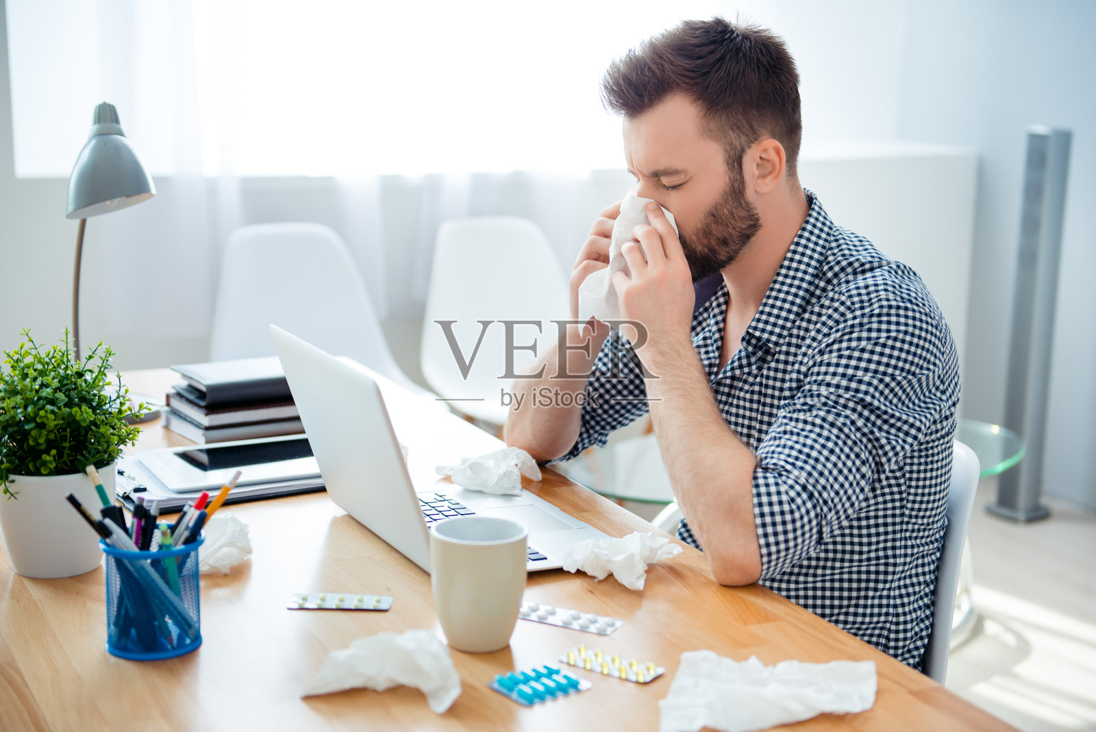 一个患有感冒的商人坐在工作场所照片摄影图片
