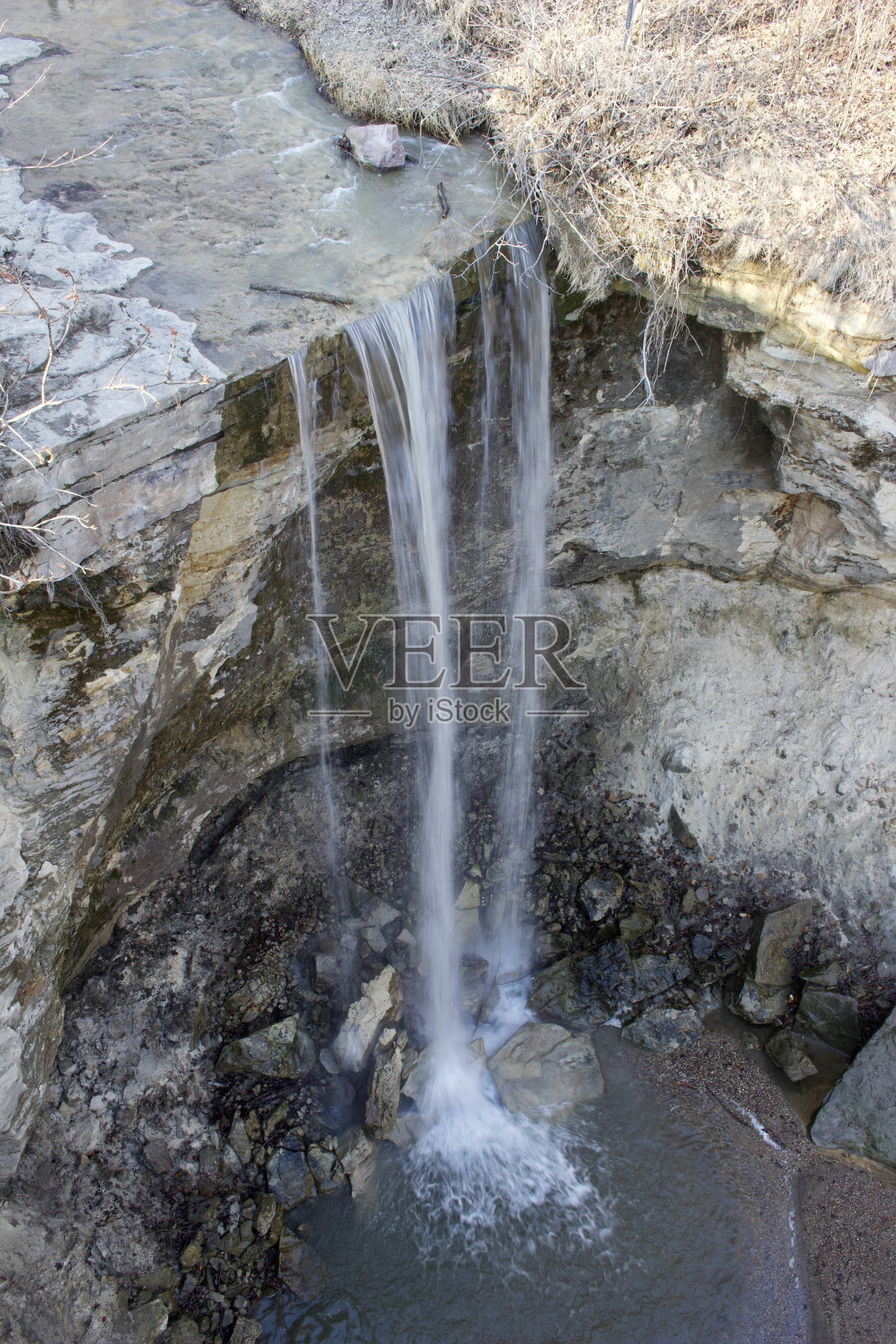 在一个乡村的背景下，一个高高的狭窄的悬崖山脊瀑布照片摄影图片