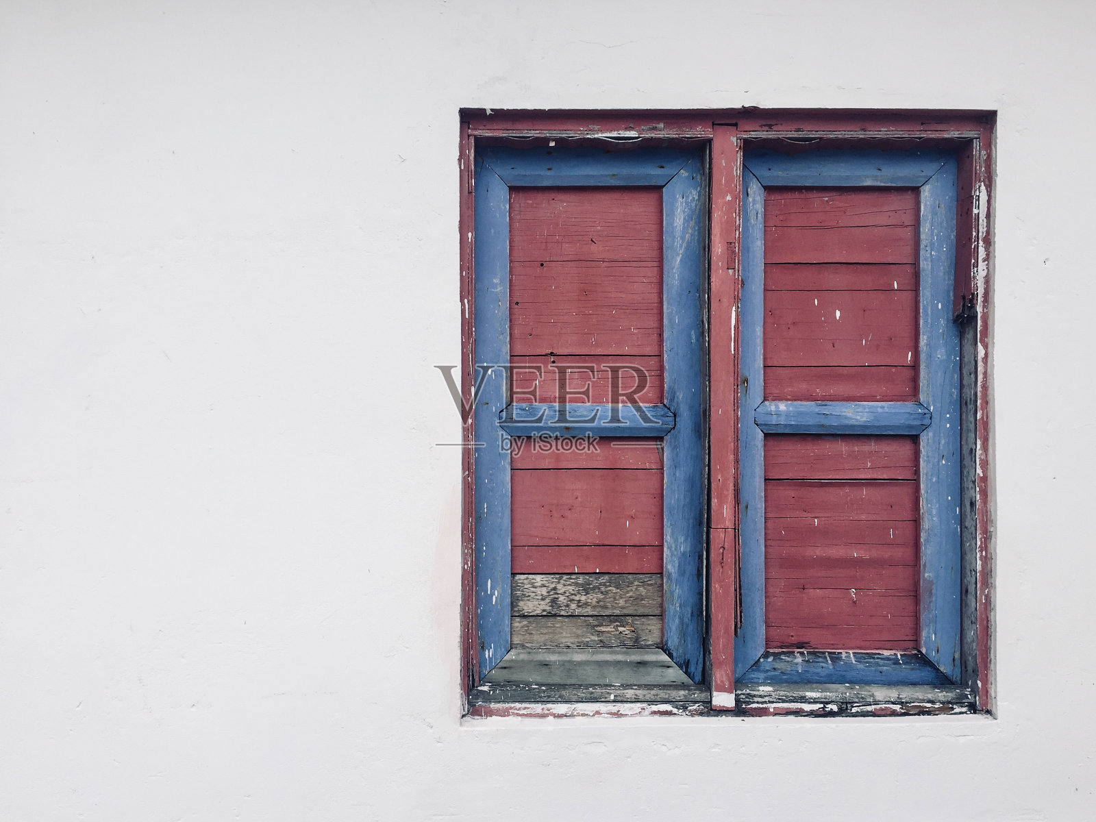 紧闭的窗户，老式的木质百叶窗隔离在白色墙壁建筑外部照片摄影图片