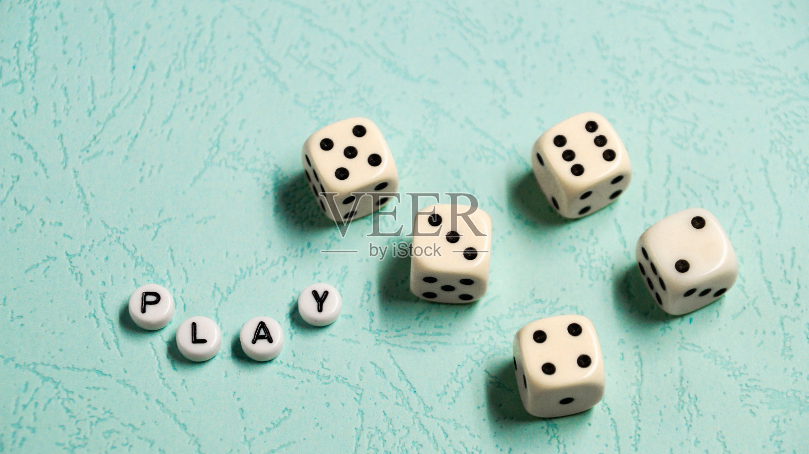 单词“Play”是由彩色的木制字母和游戏骰子组成的背景。照片摄影图片