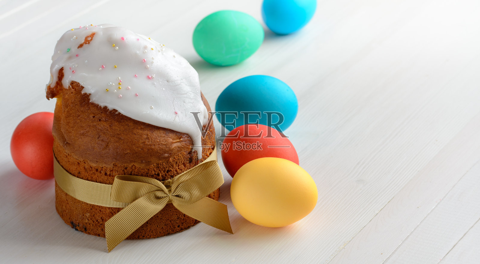 复活节蛋糕和复活节蛋放在白色的木桌上。照片摄影图片