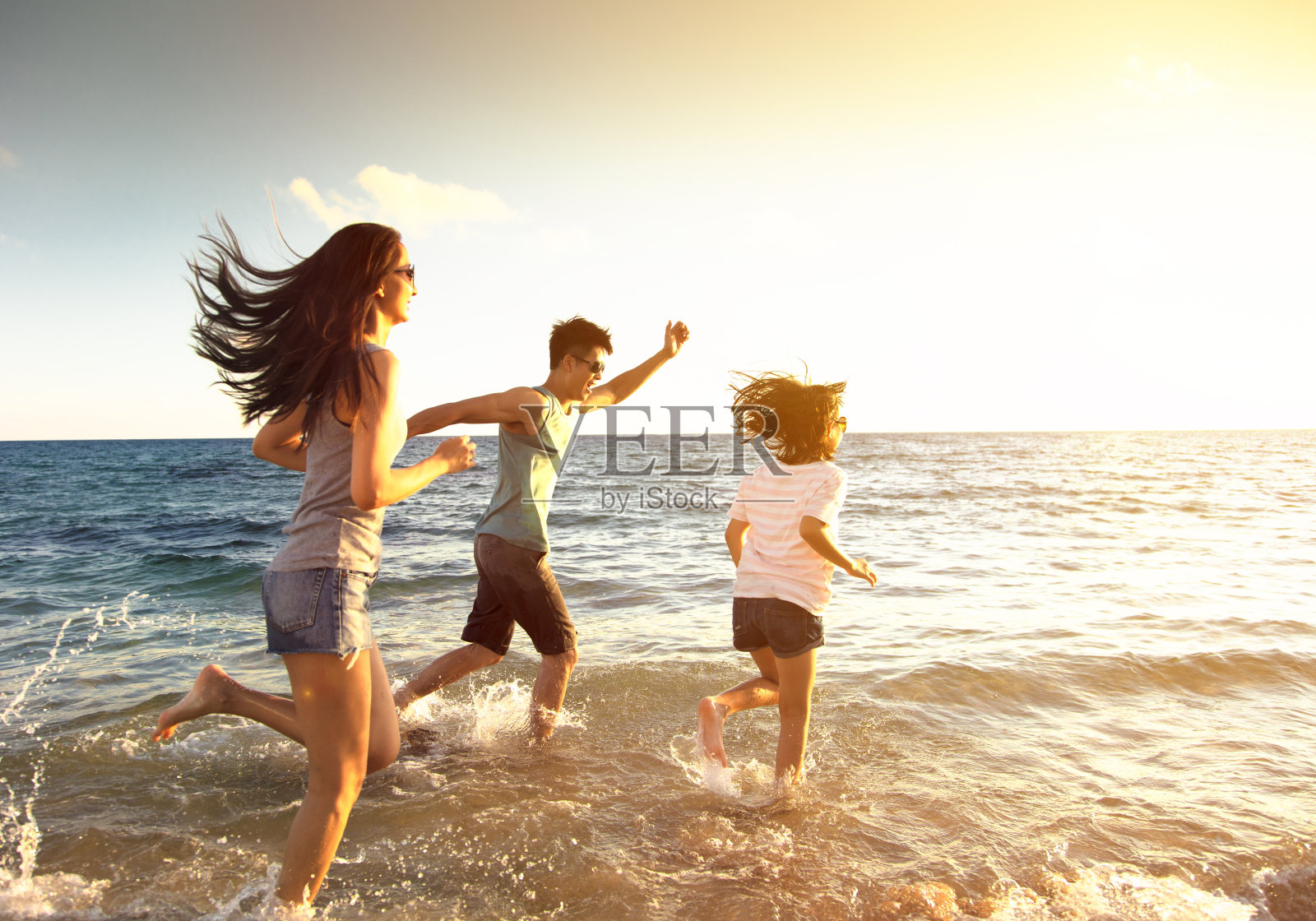 快乐的家庭在沙滩上奔跑照片摄影图片
