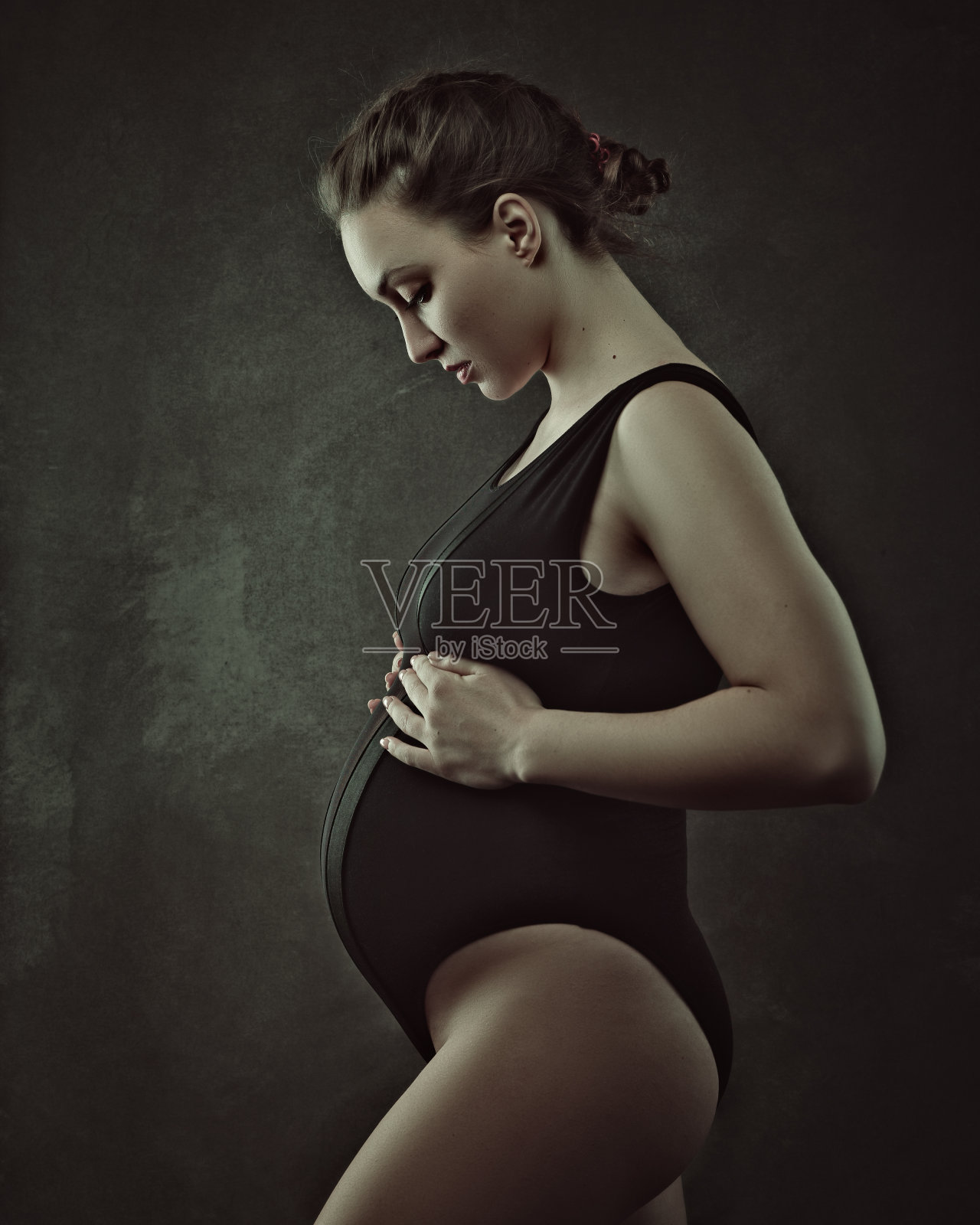的后代。一个孕妇在摄影棚里摆姿势。女性肖像照片摄影图片