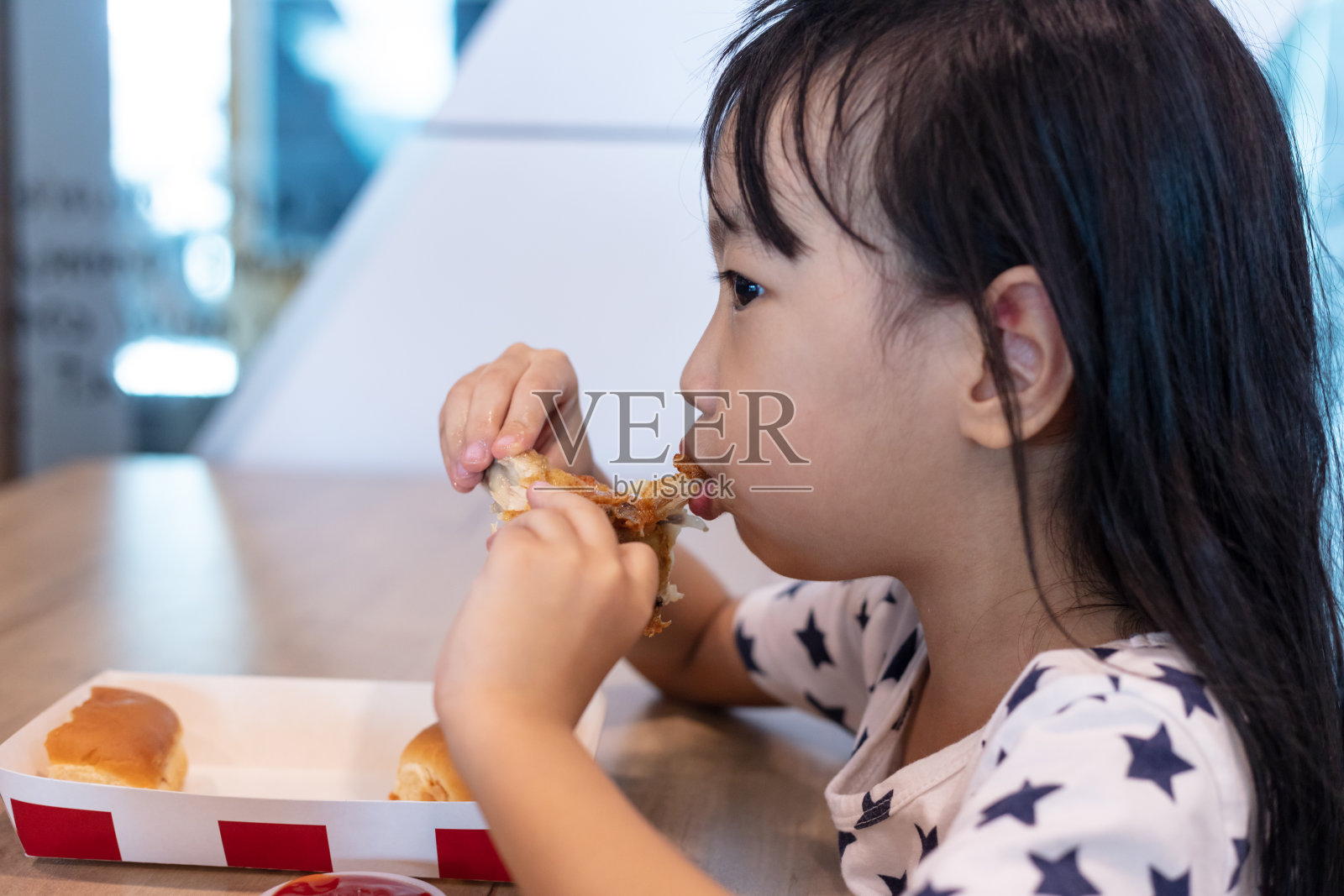 亚洲华人小女孩在吃炸鸡照片摄影图片