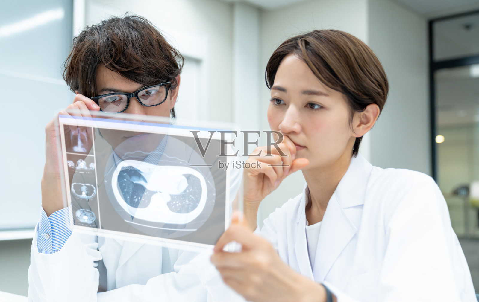 医生看起来是一个未来的平板设备。电子医疗记录。照片摄影图片