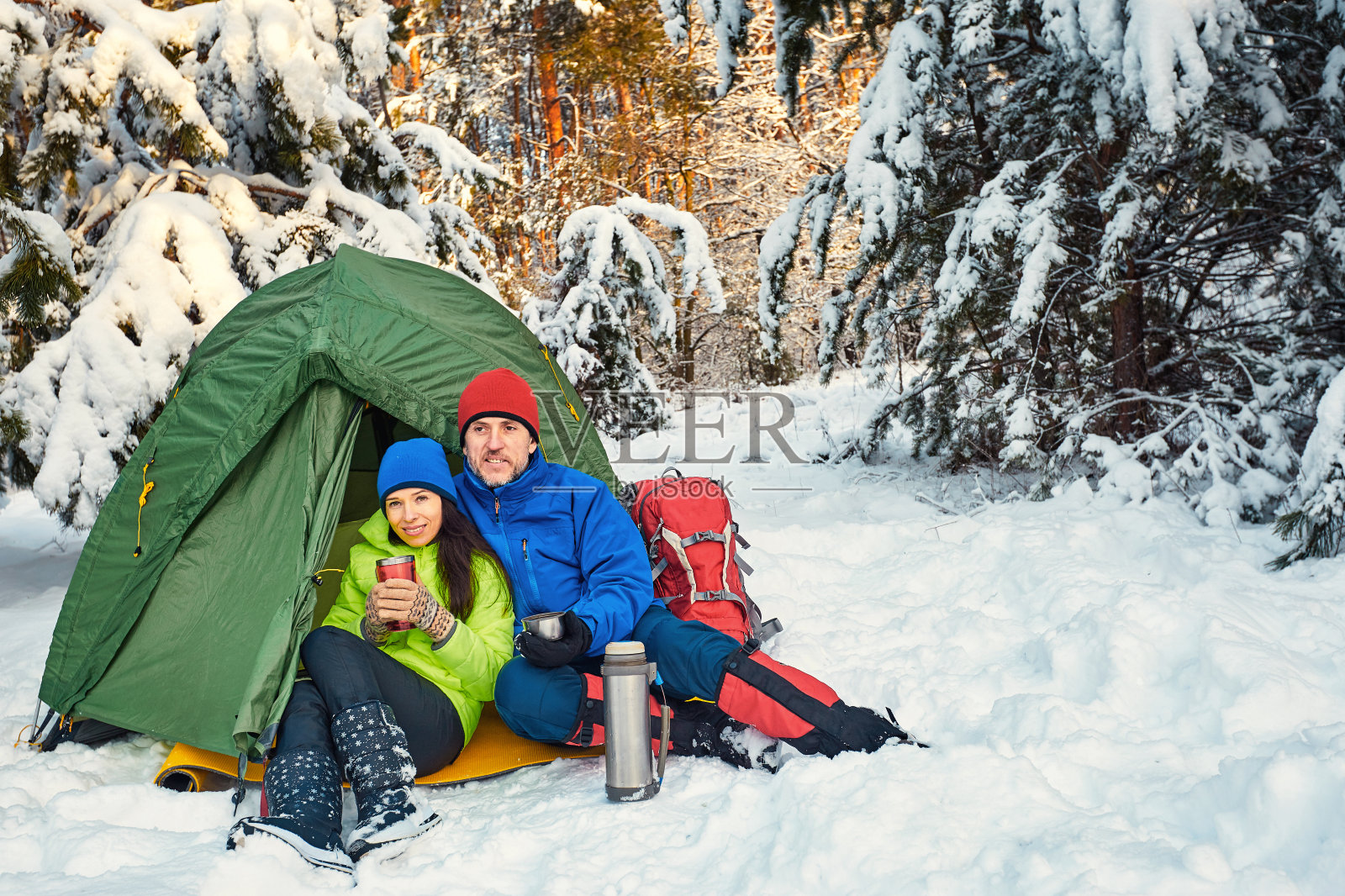 带着背包和帐篷穿过冬天的森林。照片摄影图片
