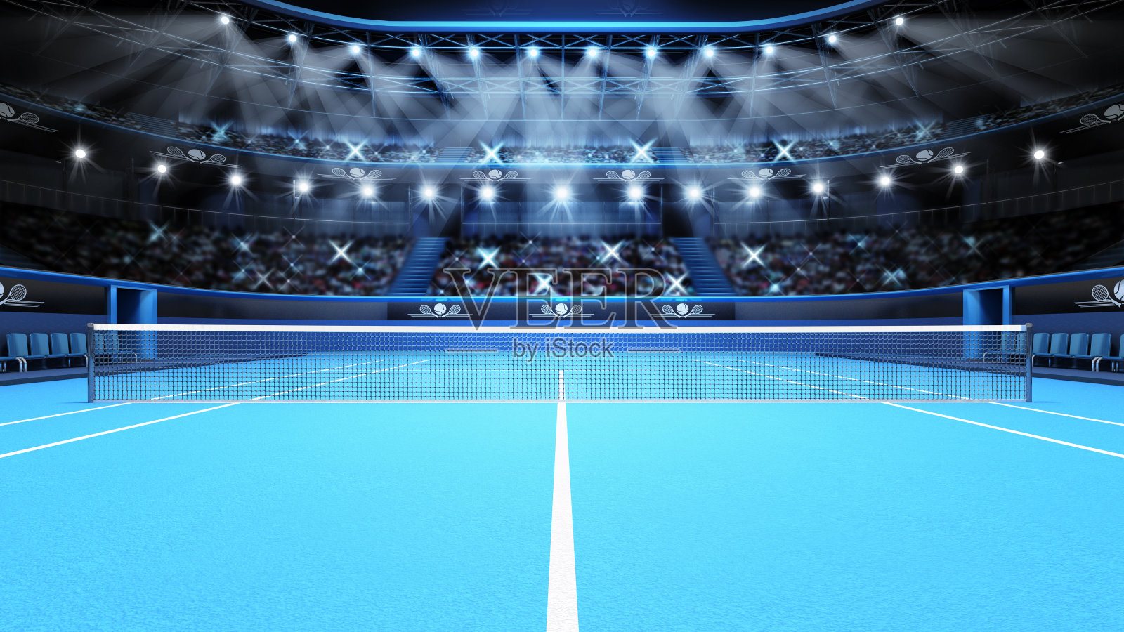 蓝色的网球场和聚光灯下挤满观众的体育场照片摄影图片