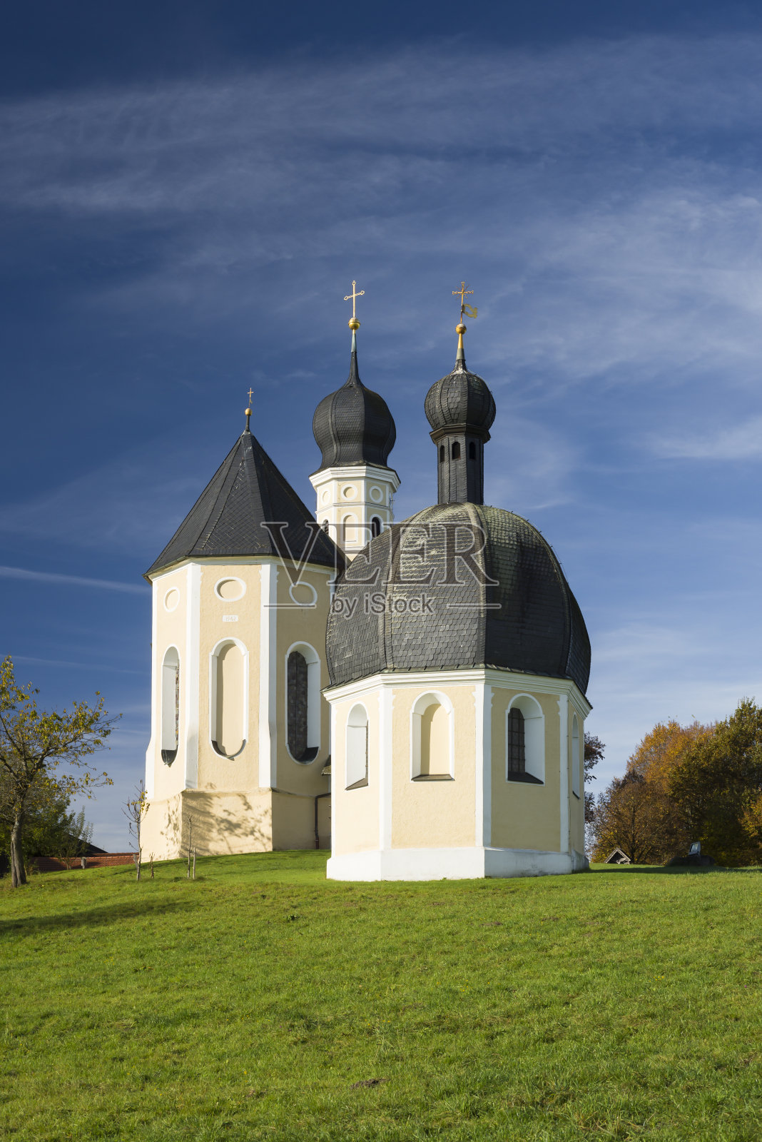 在德国巴伐利亚州早晨的蓝天下，巴洛克式的Wilparting朝圣教堂和小教堂的彩色立面、尖塔和屋顶照片摄影图片