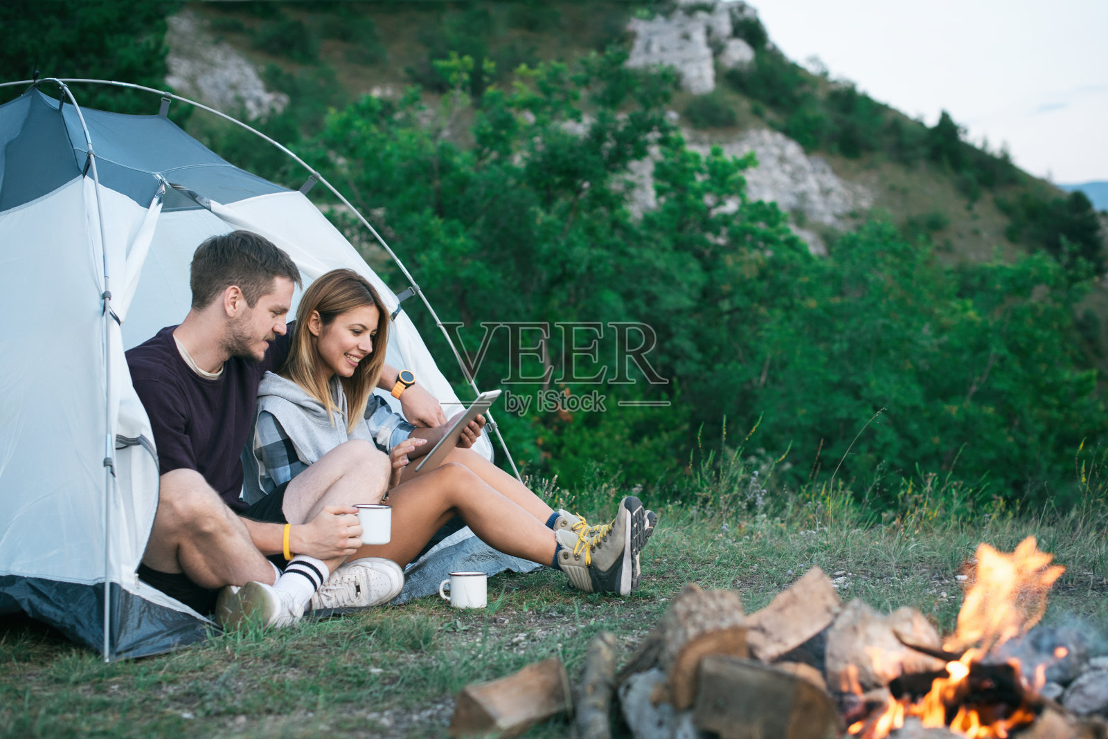 快乐的年轻夫妇在露营旅行中使用数字平板电脑照片摄影图片