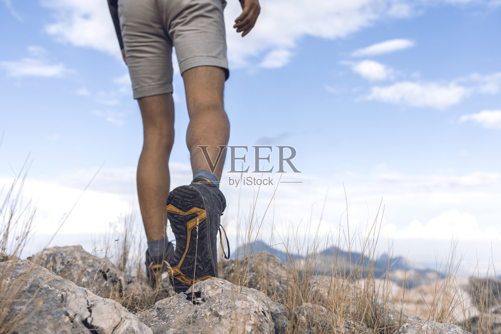 一个徒步旅行者的腿在山路上的特写镜头。照片摄影图片