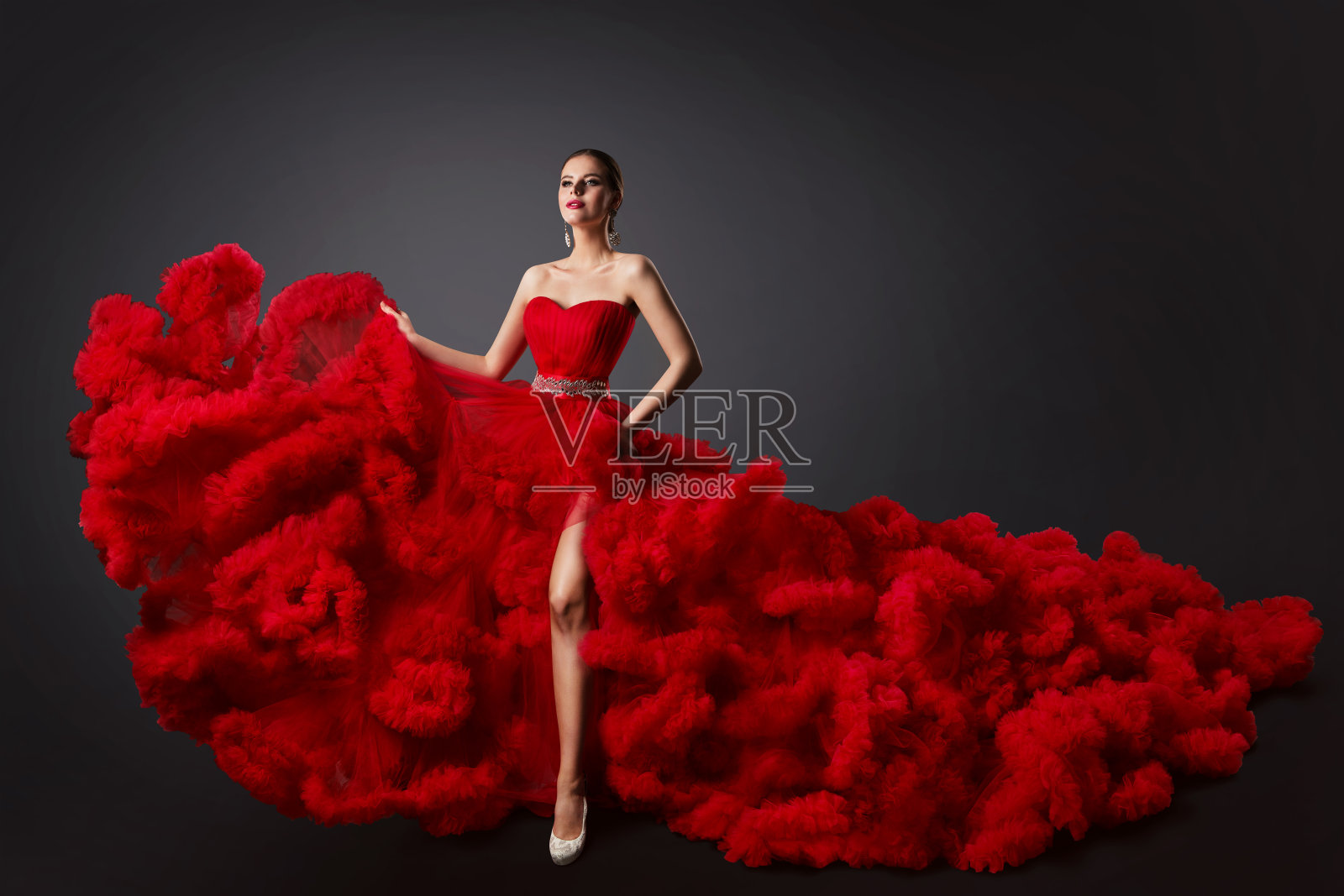 女人在红色皱裙，时装模特在长蓬松的挥舞长袍照片摄影图片