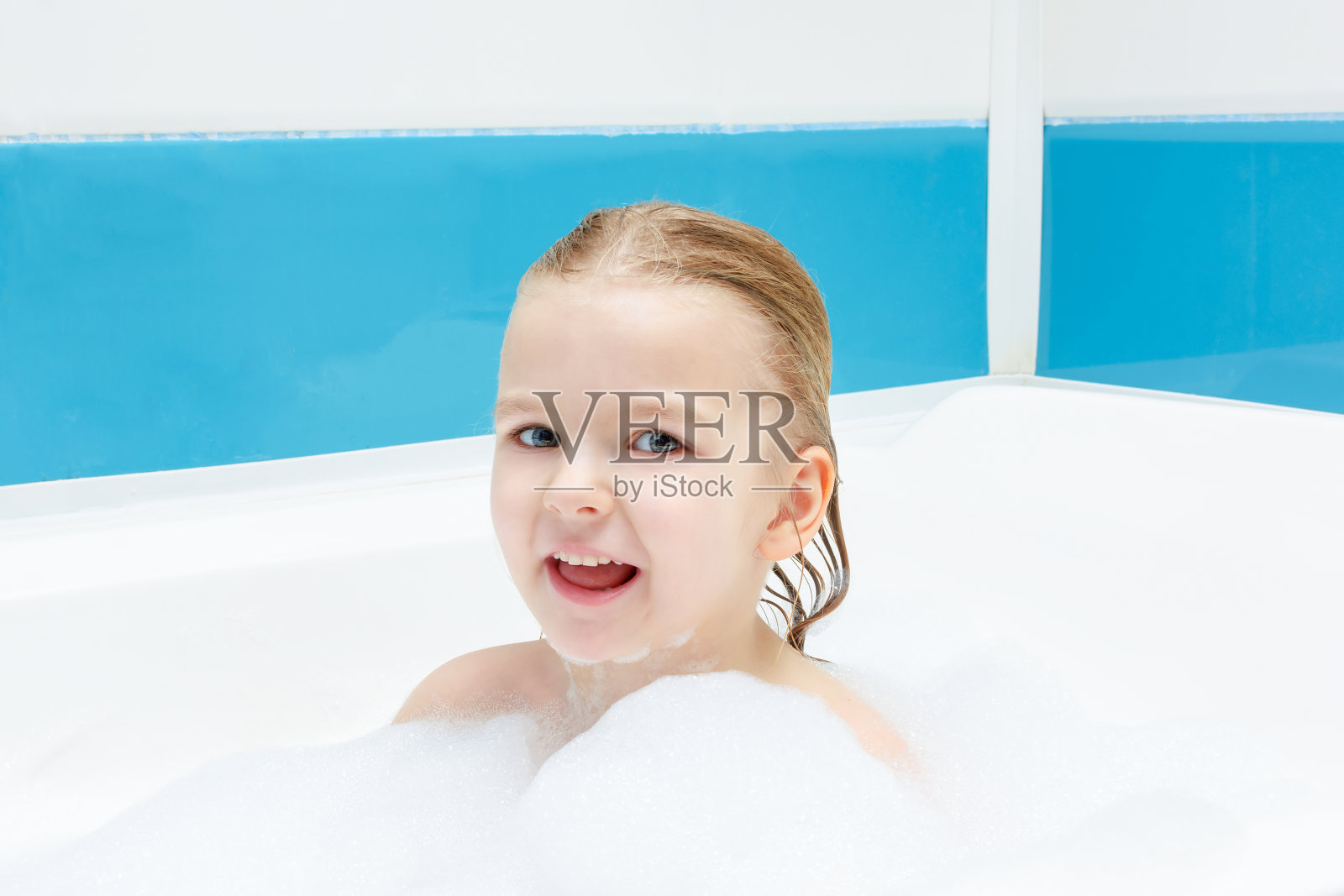 小女孩正在洗泡泡浴。快乐的微笑的孩子。光照片。照片摄影图片