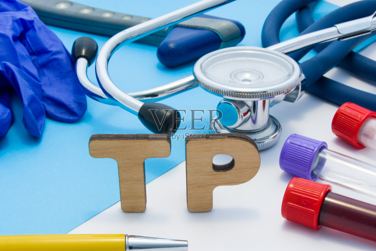 TP医学实验室缩写，意思是血液或血清中的总蛋白质。由字母组成的TP，位于带血的试管附近，听诊器和其他诊断工具和设备，乳胶手套照片摄影图片