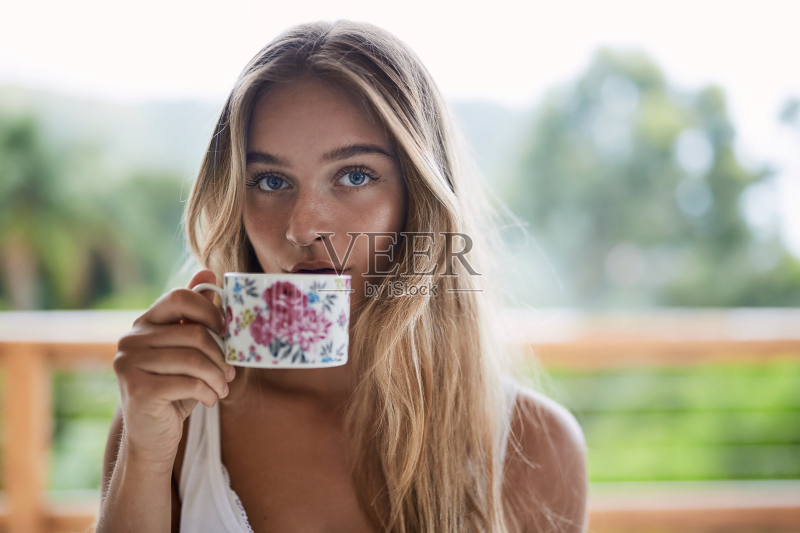 女孩用茶杯喝水照片摄影图片