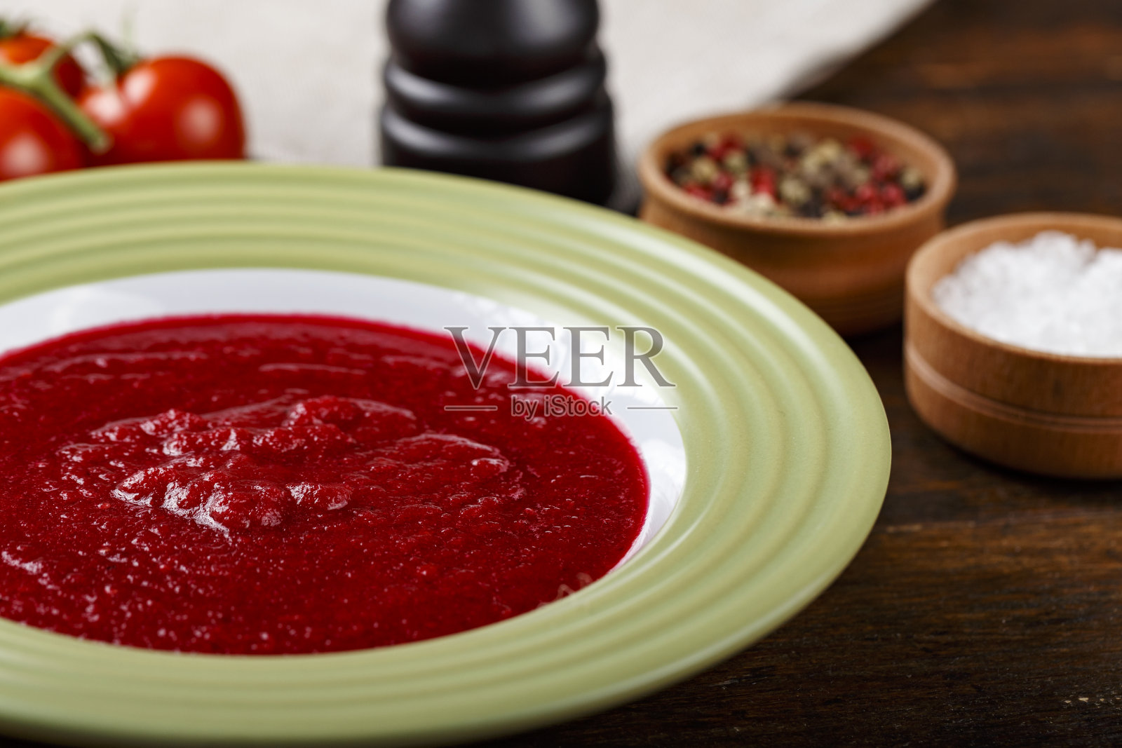 传统的意大利番茄凉菜汤放在木桌上的盘子里。照片摄影图片
