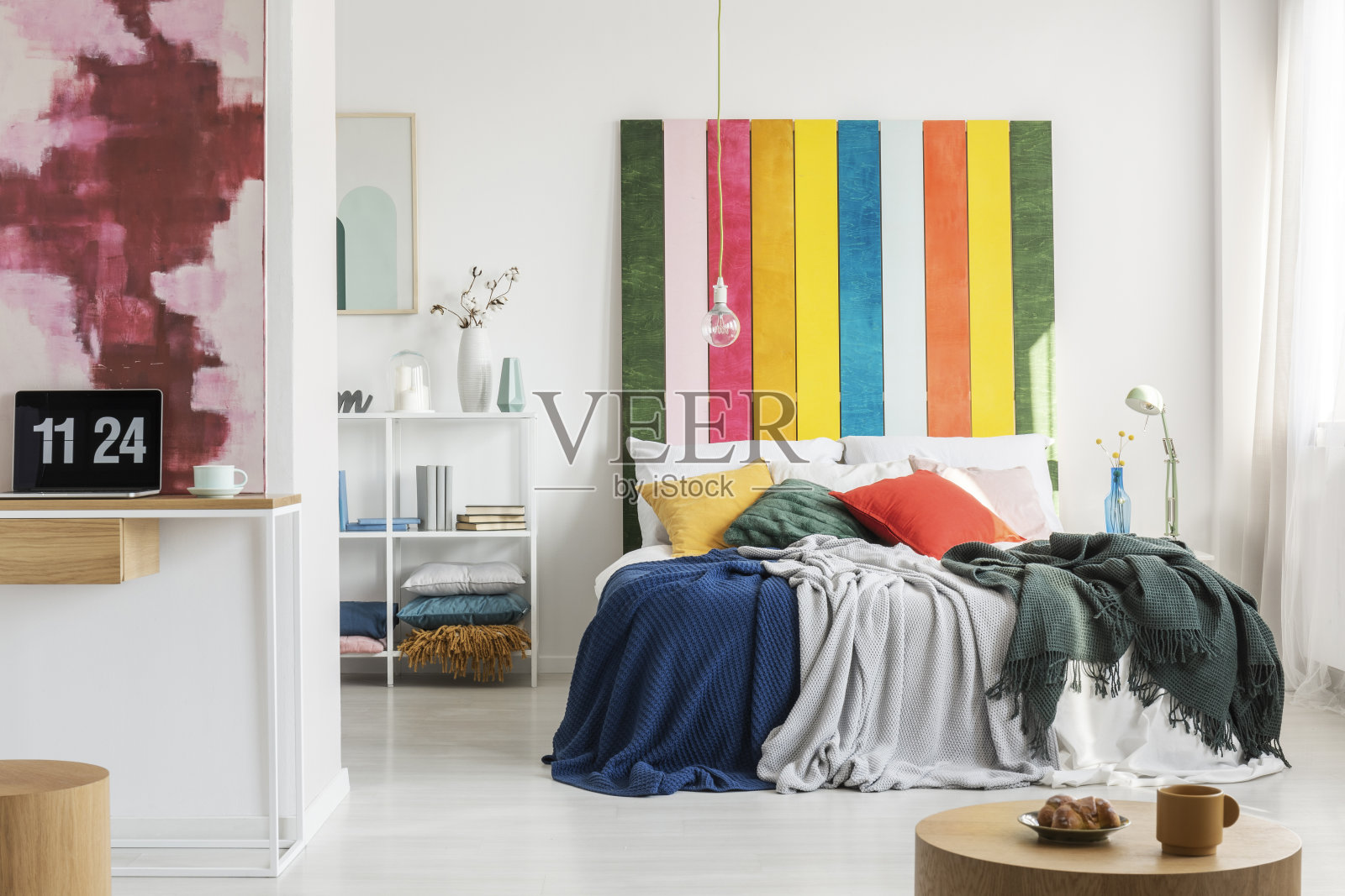 现代，开放空间的公寓内部，一个家庭办公室在前景和卧室与一个彩色的床头在背景。真实的照片照片摄影图片