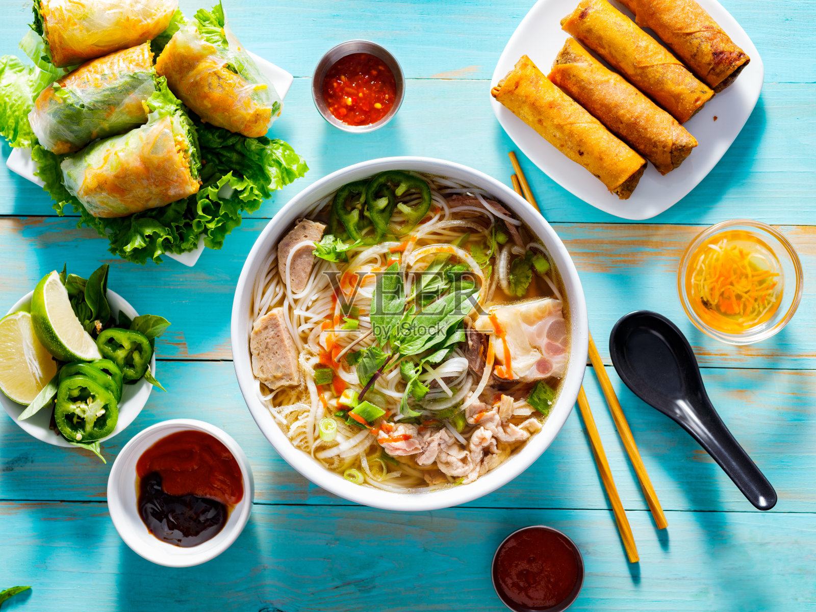 越南河粉汤，配上开胃菜，淋上辣椒酱照片摄影图片