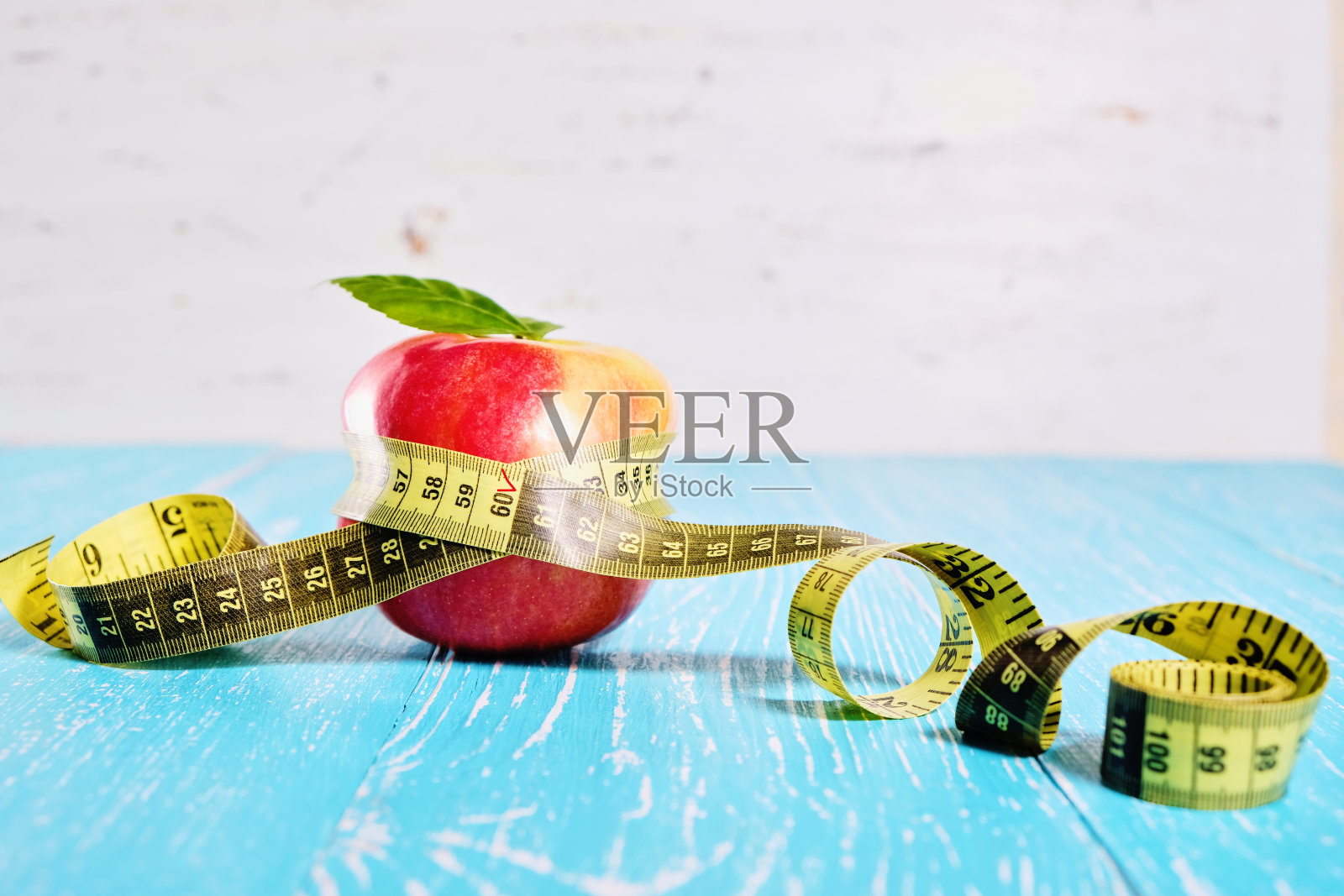用卷尺绕着苹果。饮食和减肥的概念照片摄影图片