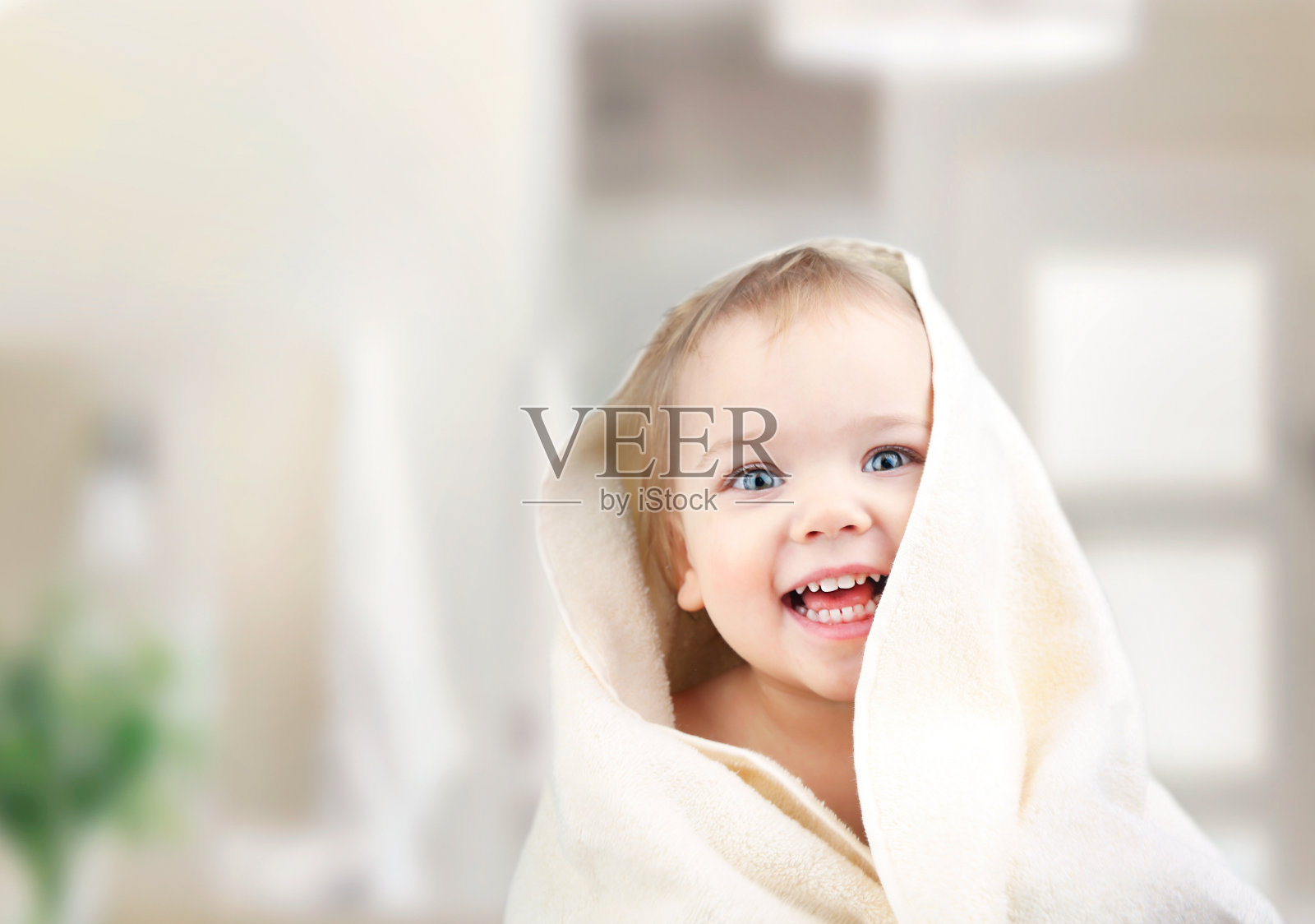 孩子在浴室用毛巾遮盖。照片摄影图片