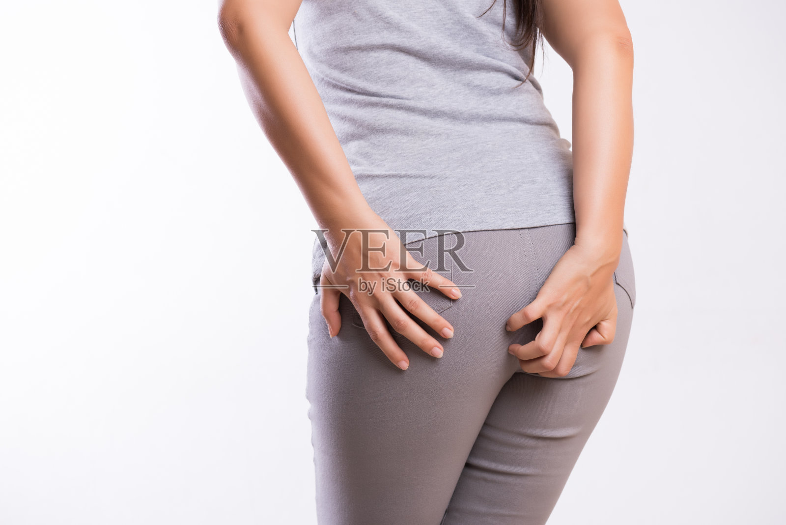 患有痔疮的妇女，因为腹痛而用手托着她的屁股。卫生保健的概念。照片摄影图片