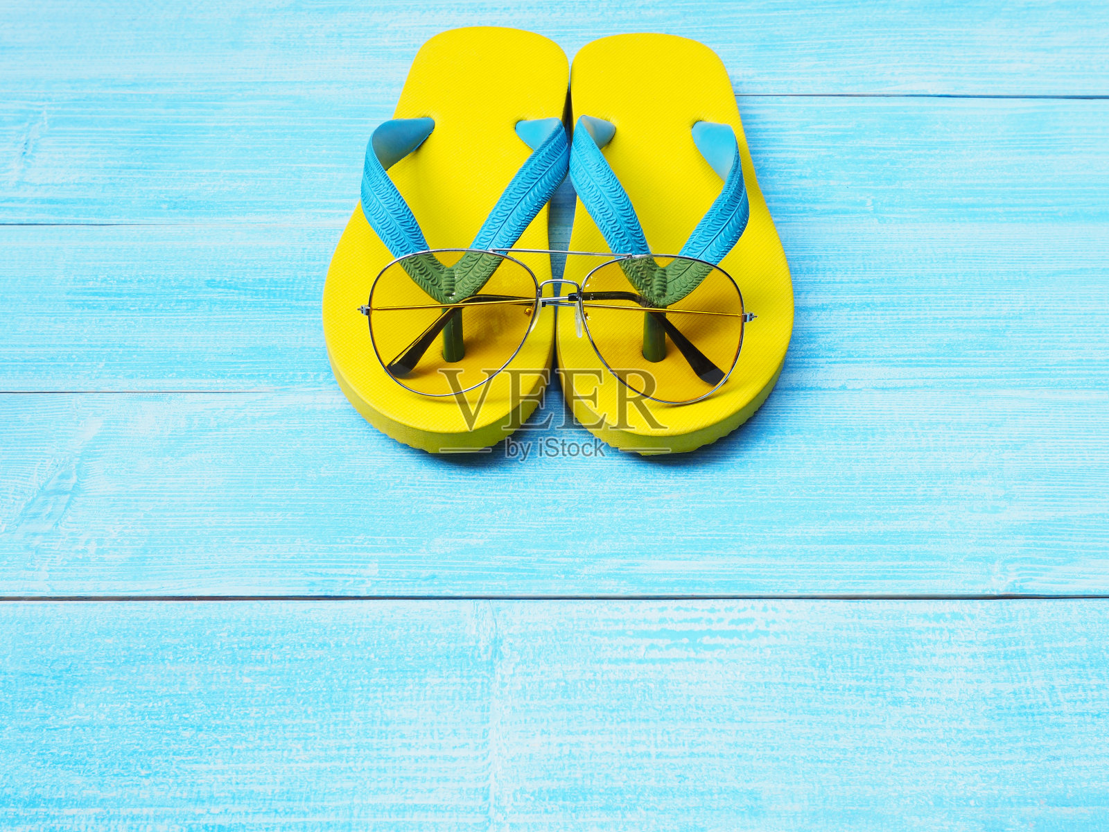 黄色的橡胶拖鞋和太阳镜照片摄影图片
