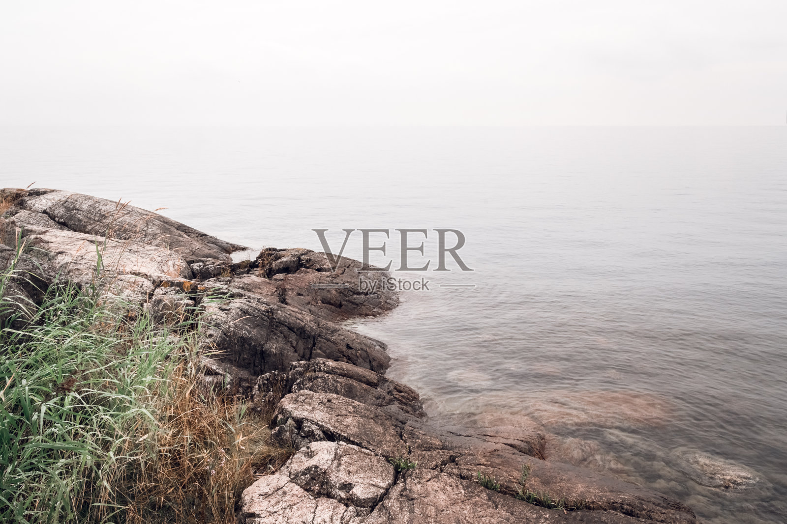 多岩石的海岸和平静的水面照片摄影图片