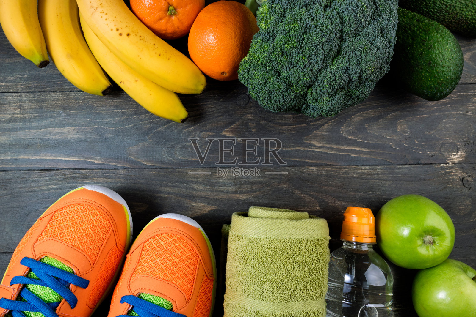 运动鞋，瓶装水，水果和蔬菜在木制的背景。成套运动器材和健康食品。健康生活方式、运动和饮食的概念照片摄影图片