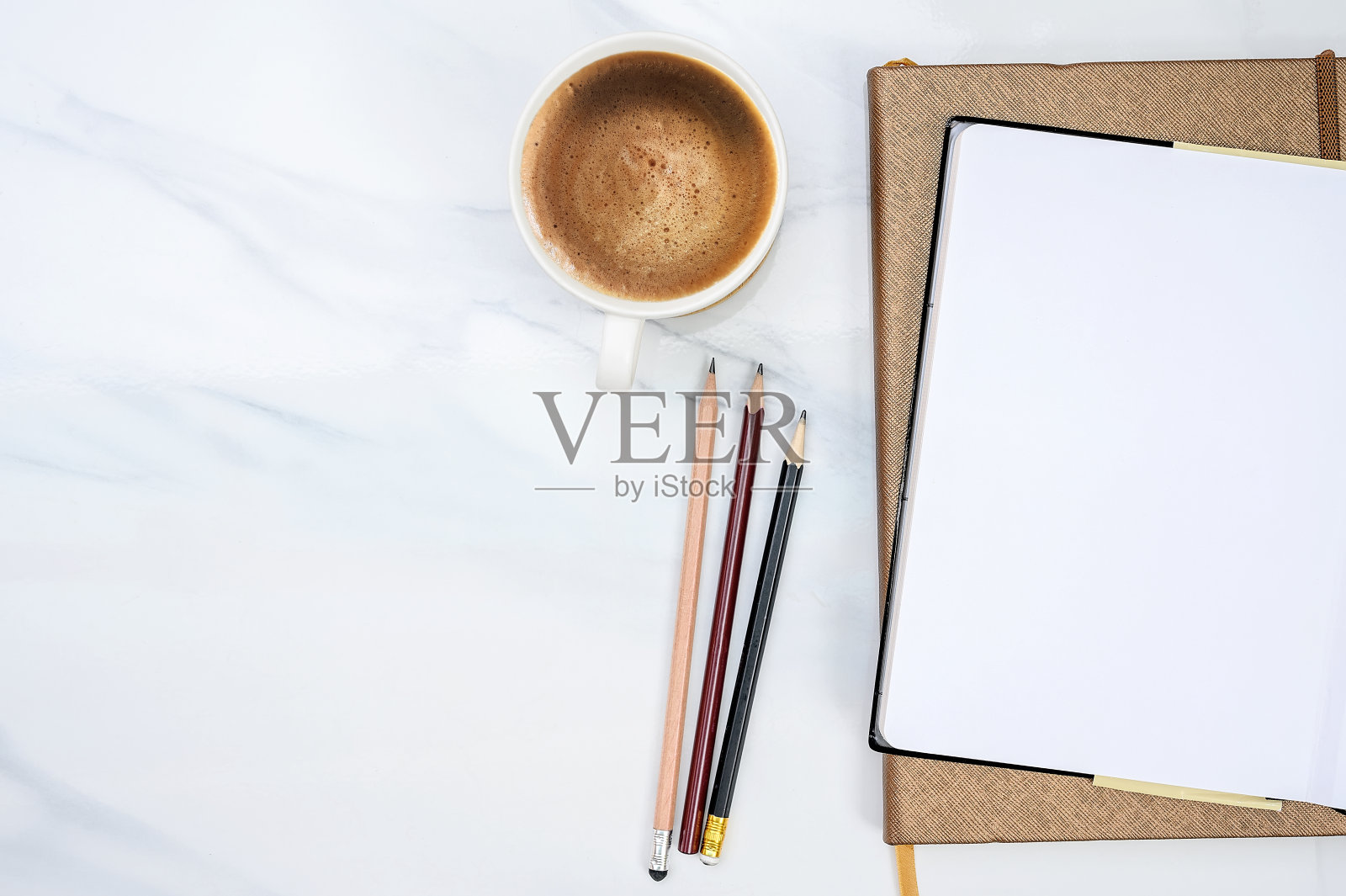 俯视图的空白页笔记本，铅笔和咖啡杯在白色桌子的背景照片摄影图片