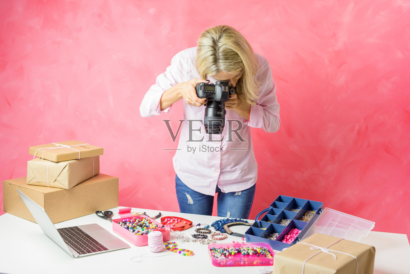 一名女子为自己创作的产品拍照，然后把它们放到网上销售照片摄影图片